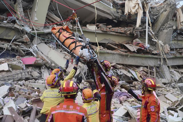 A Chinese search and rescue team carry a pregnant survivor from a collapsed building in Mandalay, Myanmar on March 31, 2025.
