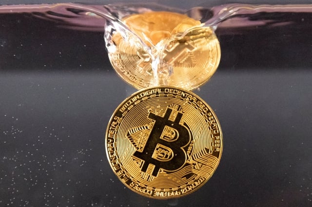 Souvenir tokens representing cryptocurrency Bitcoin plunge into water in this illustration taken May 17, 2022. REUTERS/Dado Ruvic/Illustration/File Photo