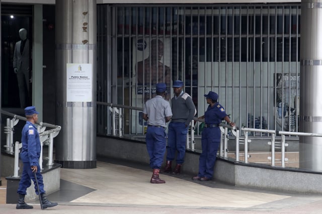 Riot police officers gather on a deserted street in downtown Harare, Zimbabwe, Monday, March 31, 2025, following calls for an anti-government protest. (AP Photo/Aaron Ufumeli)
