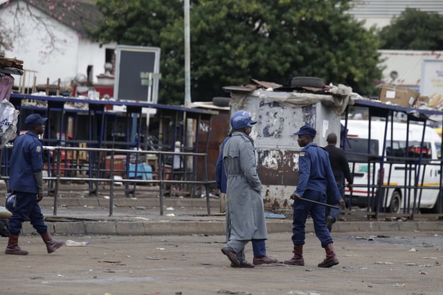 Riot police officers patrol a deserted market area in Harare, Zimbabwe, Monday, March 31, 2025, following calls for an anti-government protest. (AP Photo/Aaron Ufumeli)