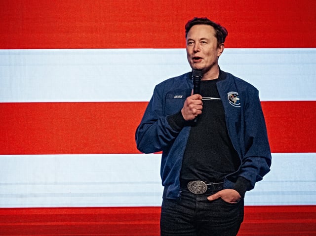 Elon Musk, chief executive officer of Tesla Inc., speaks during an America PAC town hall ahead of the Wisconsin Supreme Court election at the KI Convention Center in Green Bay, Wisconsin, US, on Sunday, March 30, 2025. Musk's plan to hand out $1 million checks to two residents for participating in Wisconsin's Supreme Court election is barred by state law, a new complaint said Friday. Photographer: Jamie Kelter Davis/Bloomberg