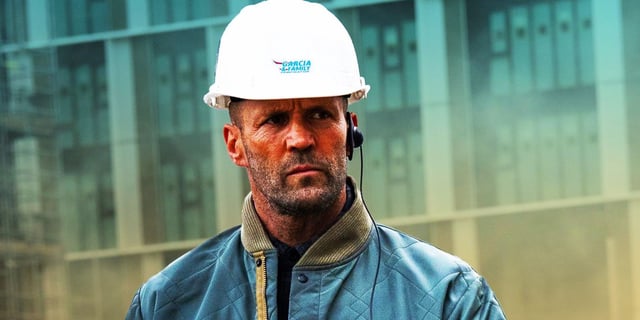 Jason Statham as Levon Cade at a construction site wearing a hard hat in A Working Man.