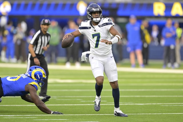 Jan 5, 2025; Inglewood, California, USA; Seattle Seahawks quarterback Geno Smith (7) scrambles away from Los Angeles Rams linebacker Byron Young (0) and throws for a touchdown in the first half at SoFi Stadium. Mandatory Credit: Jayne Kamin-Oncea-Imagn Images/File Photo