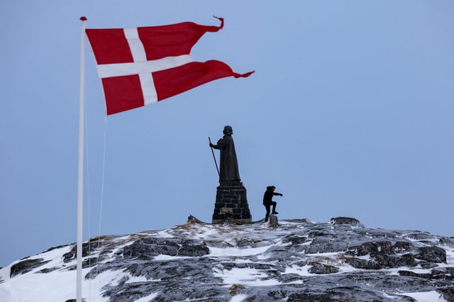 A man walks as Danish flag flutters next to Hans Egede Statue ahead of a March 11 general election in Nuuk, Greenland, March 9, 2025. REUTERS/Marko Djurica/File Photo