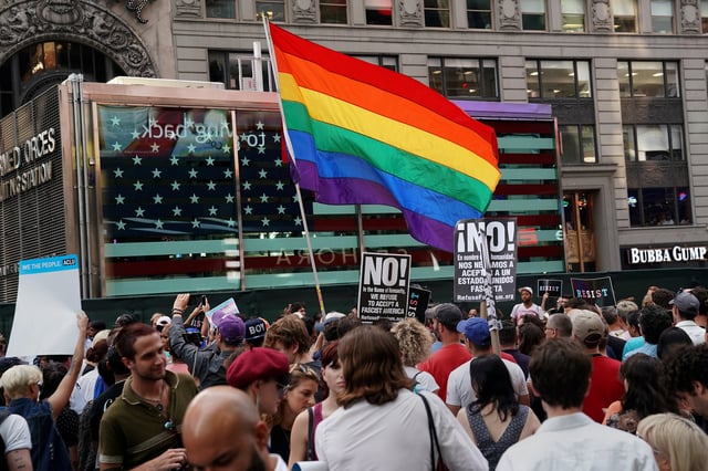 A rainbow flag flies as people protest U.S. President Donald Trump's announcement that he plans to reinstate a ban on transgender individuals from serving in any capacity in the U.S. military, in Times Square, in New York City, New York, U.S., July 26, 2017. REUTERS/Carlo Allegri/File Photo