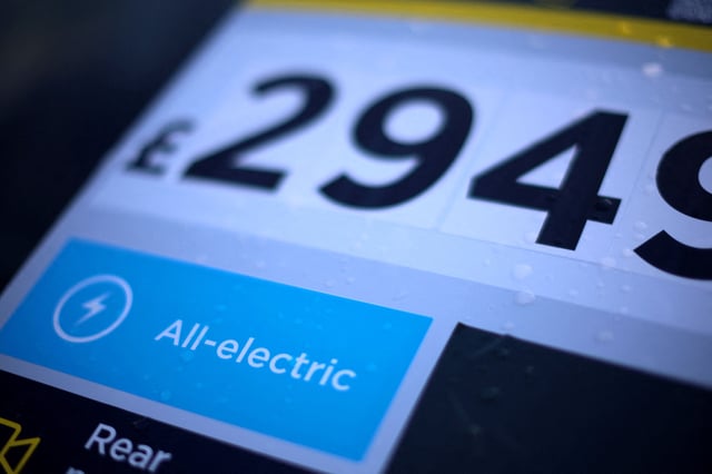 A price sticker is seen on the windscreen of a used Tesla electric car outside the showroom of a used car dealer in Manchester, Britain, October 19, 2023. REUTERS/Phil Noble/File Photo