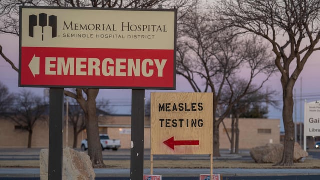 SEMINOLE, TEXAS - FEBRUARY 27: Signs point the way to measles testing in the parking lot of the Seminole Hospital District across from Wigwam Stadium on February 27, 2025 in Seminole, Texas. (Photo by Jan Sonnenmair / GETTY IMAGES NORTH AMERICA / Getty Images via AFP)