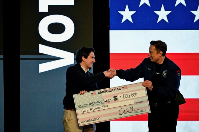 U.S. President Donald Trump's adviser Elon Musk gives a check to an audience member during a rally in support of a conservative state Supreme Court candidate of an April 1 election in Green Bay, Wisconsin, U.S. March 30, 2025.  REUTERS/Vincent Alban/File Photo