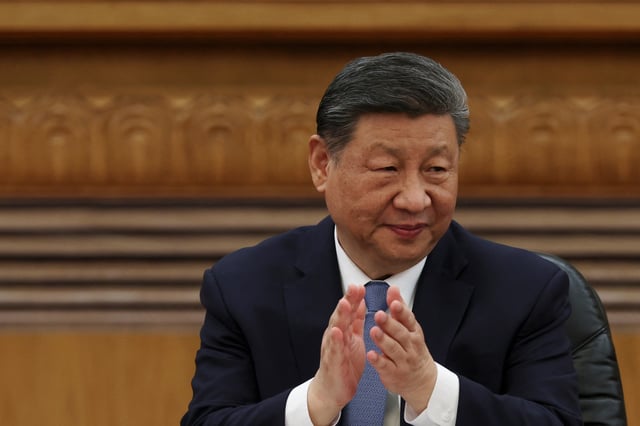 Chinese President Xi Jinping applauds at a meeting with foreign business leaders at the Great Hall of the People in Beijing, China March 28, 2025. REUTERS/Florence Lo/File Photo