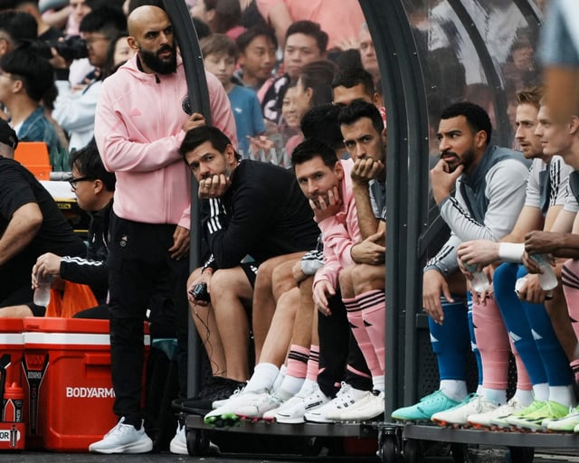 Soccer Football - Friendly - Hong Kong v Inter Miami - Hong Kong Stadium, Hong Kong - February 4, 2024 Inter Miami's Lionel Messi, Sergio Busquets and teammates sit on the substitute bench during the match as Lionel Messi security guard Yassine Cheuko looks on REUTERS/Lam Yik/File Photo