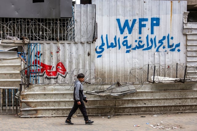A boy walks past a closed-down bakery that ran out of flour in Gaza City on April 1, 2025. Israel resumed intense air strikes across Gaza on March 18, followed by ground operations, after talks on extending a ceasefire with the Palestinian militant group Hamas reached an impasse.