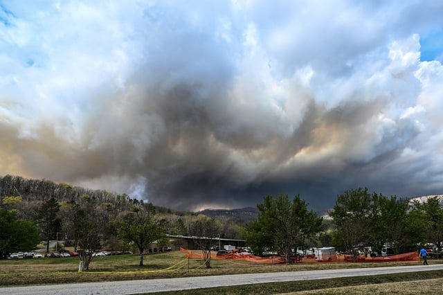 Smoke from the Table Rock fire rises behind the briefing center for the incident command post in Pickens County, S.C., on March 29, 2025.
