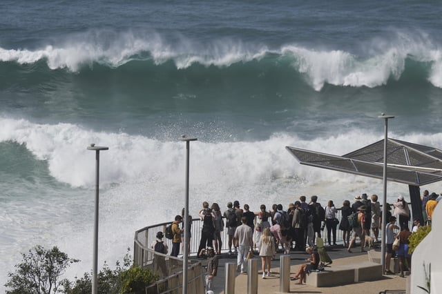People watch as large swells hit Sydney's Bondi Beach Wednesday, April 2, 2025. (AP Photo/Mark Baker)