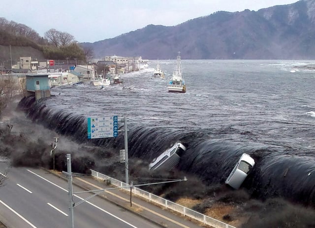 This picture taken on March 11, 2011, shows a tsunami breaching an embankment and flowing into the city of Miyako in Iwate prefecture shortly after a 9.0 magnitude earthquake hit the region of northern Japan.