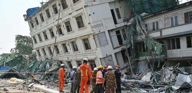 Des équipes de secouristes chinois et bélarusses se coordonnent sur le site d'un bâtiment effondré à Mandalay le 2 avril 2025, cinq jours après le tremblement de terre qui a frappé le centre de la Birmanie