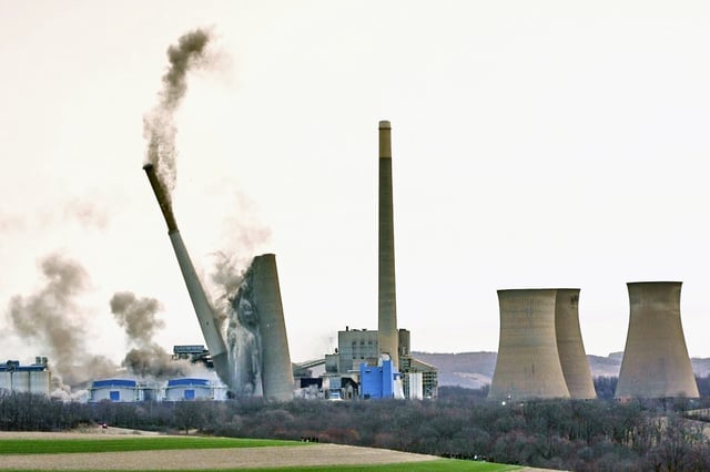 The smokestacks of the former coal-fired Homer City Generating Station crumble in a planned demolition to make way for a new natural gas-fired power plant in Homer City, Pa., Saturday, March 22, 2025. (AP Photo/Gene J. Puskar)