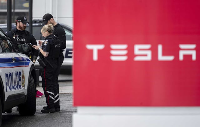 Officers from Ottawa Police Service are seen at a Tesla Service and Showroom centre after it was damaged with pink spray paint in Ottawa, on Monday, March 31. Tesla reported a significant drop in vehicle deliveries for the first quarter of 2025, with a 13% decline compared to the same period last year. 
