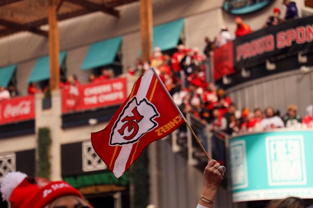 A person holds a flag, while fans celebrate, as Kansas City take on the San Francisco 49ers for Super Bowl 58, prior to kickoff, in Kansas City, Missouri, U.S., February 11, 2024. REUTERS/Maria Alejandra Cardona/File Photo