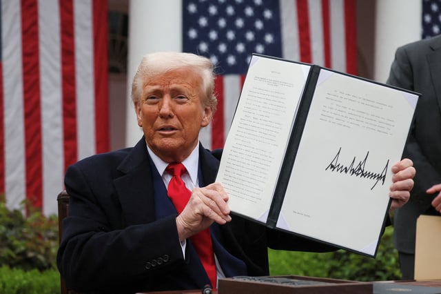 U.S. President Donald Trump holds a signed executive order on tariffs, in the Rose Garden at the White House in Washington, D.C., U.S., April 2, 2025. REUTERS/Leah Millis/File Photo