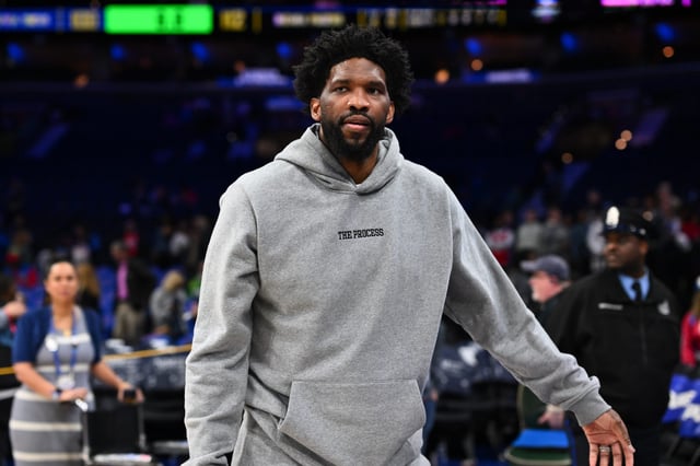 Joel Embiid in a sweatsuit at a Sixers game.
