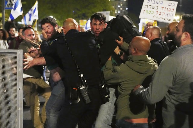 Israeli police push back people protesting against Prime Minister Benjamin Netanyahu's government outside the Knesset, Israel's parliament in Jerusalem, Monday, March 31, 2025. (AP Photo/Ohad Zwigenberg)