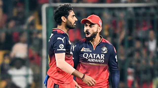 Royal Challengers Bengaluru's Virat Kohli and Bhuvneshwar Kumar celebrate the wicket of Gujarat Titans' captain Shubman Gill