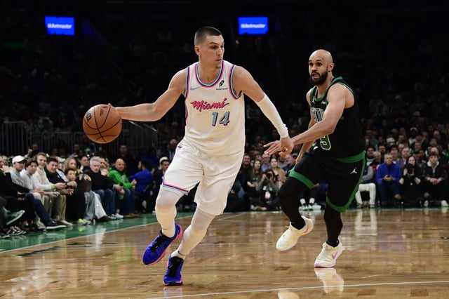 Apr 2, 2025; Boston, Massachusetts, USA; Miami Heat guard Tyler Herro (14) controls the ball while Boston Celtics guard Derrick White (9) defends during the first half at TD Garden. Mandatory Credit: Bob DeChiara-Imagn Images