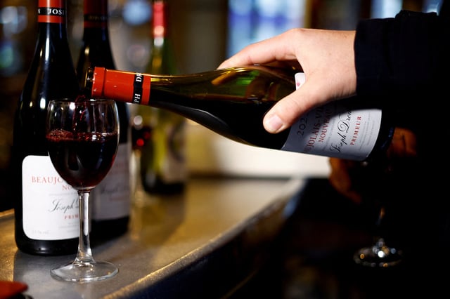 A customer pours a glass of Beaujolais Nouveau wine at Le Mesturet restaurant in Paris, France, November 16, 2023. REUTERS/Sarah Meyssonnier/File Photo