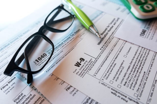 Stock image/file photo: Tax return forms with a pen and glasses.