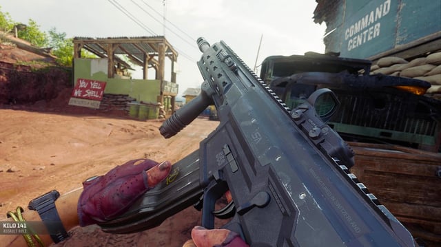 BO6 Kilo 141 loadout - A player reloading the rifle next to a parked truck on a muddy path.