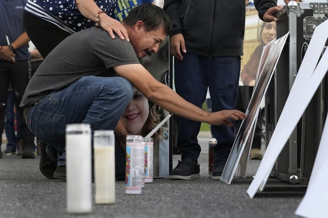 FILE - Daniel Delgado reaches to touch a photo of his wife, Monica Hernandez, who died at Impact Plastics during flooding caused by Hurricane Helene, at a vigil for victims of the tragedy in Erwin, Tenn., Oct. 3, 2024. (AP Photo/Jeff Roberson, File)