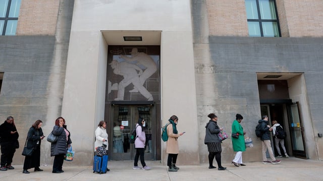a line of workers waiting to collect their belongings after being cut from the Health and Human Services agency