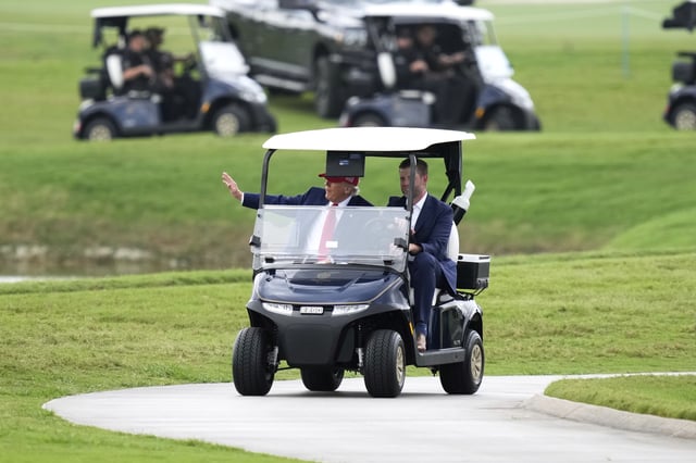 President Donald Trump, driven by his son Eric Trump, arrives at Trump National Doral during the LIV Golf Miami tournament, Thursday, April 3, 2025, in Miami. (AP Photo/Alex Brandon)
