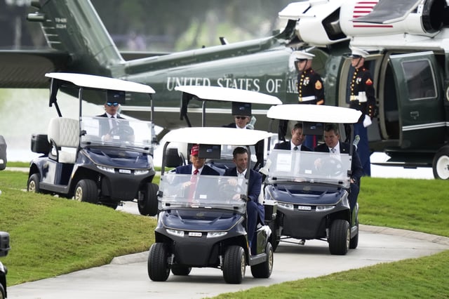 President Donald Trump, driven by his son Eric Trump, arrives at Trump National Doral during the LIV Golf Miami tournament, Thursday, April 3, 2025, in Miami. (AP Photo/Alex Brandon)