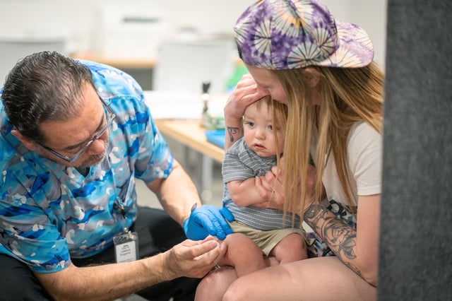 LUBBOCK, TEXAS - MARCH 01: One year-old River Jacobs is held by his mother, Caitlin Fuller, while he receives an MMR vaccine from Raynard Covarrubio, at a vaccine clinic put on by Lubbock Public Health Department on March 1, 2025 in Lubbock, Texas. Cases of Measles are on the rise in West Texas as over 150 confirmed case have been seen with one confirmed death.(Photo by Jan Sonnenmair/Getty Images)