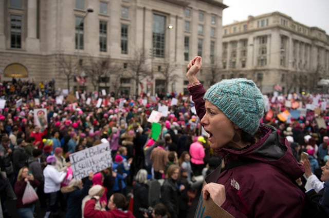 Jan 21, 2017; Washington, DC, USA; A woman rallies fellow protestors as thousands of marchers walk down Pennsylvania Ave in protest of newly elected president Donald J. Trump.