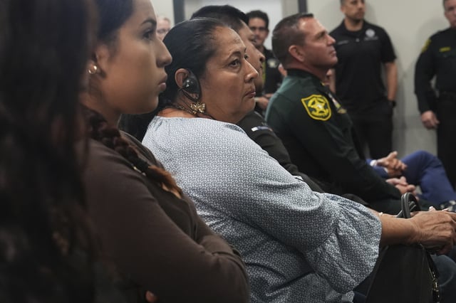 Family members of a homicide victim listen to U.S. Attorney General Pam Bondi announce the arrest of gang members involved in four homicides, Friday, April 4, 2025, in Fort Lauderdale, Fla. (AP Photo/Marta Lavandier)