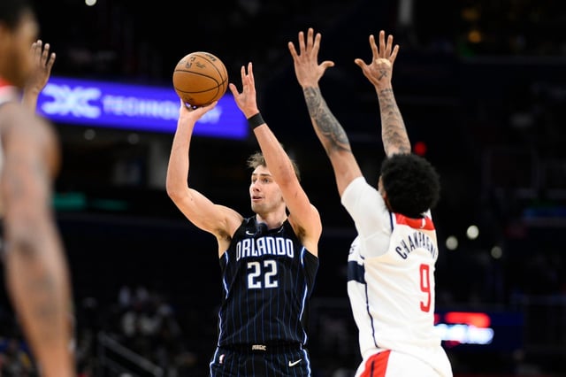 Orlando Magic forward Franz Wagner (22) shoots past Washington Wizards forward Justin Champagnie (9) during the second half of an NBA basketball game, Thursday, April 3, 2025, in Washington. (AP Photo/Nick Wass)