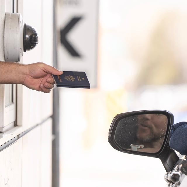 A Canada Border Services officer hands passports back to a visitor entering Canada from Vermont at the Highway 55 Port of Entry in Stanstead, Que., on Thursday, March 13, 2025. Canadians are facing a new travel advisory regarding travel to the U.S., warning about "scrutiny at border points" from U.S. border guards and that they could be detained if denied entry. THE CANADIAN PRESS/Christinne Muschi