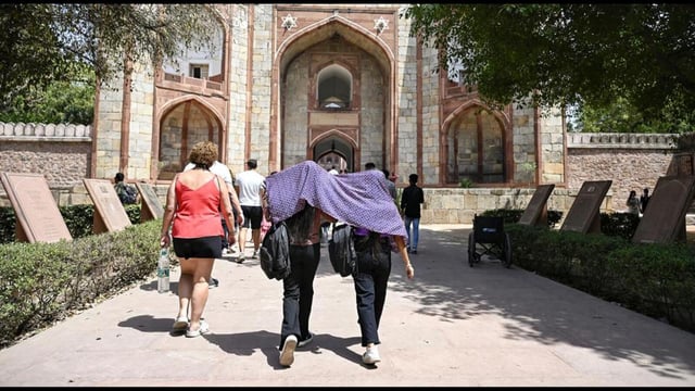 Girls drape a scarf as the sun casts its heat at Humayun's tomb in New Delhi on Wednesday. (ANI)