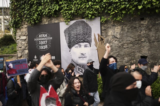 University students march past a photograph of Turkey's founder Mustafa Kemal Ataturk in Istanbul, Turkey, Thursday, March 27, 2025, during a protest after Istanbul's Mayor Ekrem Imamoglu was arrested and sent to prison. (AP Photo/Francisco Seco)