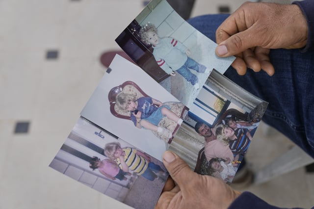 Khalid Ahmad, holds childhood photos of his son, Waleed, at his family home in the West Bank town of Silwad, northeast of Ramallah, Wednesday, March 26, 2025. (AP Photo/Nasser Nasser)