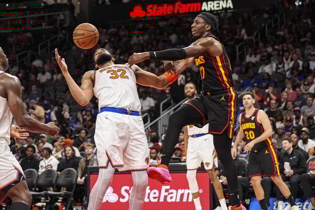 Apr 5, 2025; Atlanta, Georgia, USA; New York Knicks center Karl-Anthony Towns (32) catches a rebound against Atlanta Hawks forward Onyeka Okongwu (17) during the second half at State Farm Arena. Mandatory Credit: Dale Zanine-Imagn Images
