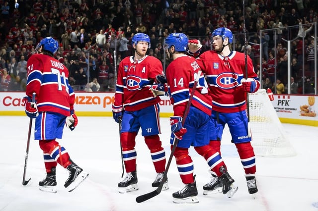 Montreal Canadiens centre Nick Suzuki (14), celebrates with teammates Jake Evans (71), Mike Matheson (8) and Joel Armia (40) after scoring during third period NHL hockey action against the Boston Bruins in Montreal, on Thursday, April 3, 2025. THE CANADIAN PRESS/Christopher Katsarov