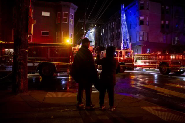 Residents of San Francisco’s Nob Hill watch firefighters battle a major blaze at a residential building at Larkin and Washington streets Saturday night. 
 