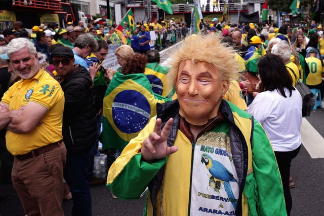 A supporter of former President Jair Bolsonaro wears a mask of U.S. President Donald Trump attends a demonstration demanding amnesty for those arrested for 2023's alleged coup attempt, in Sao Paulo, Sunday, April 6, 2025. (AP Photo/Ettore Chiereguini)
