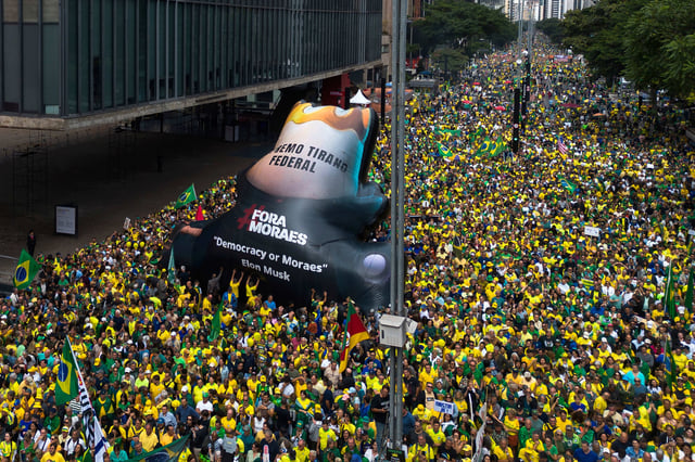 An inflatable with text that reads in Portuguese, "Supreme Court tyrant," in reference to Supreme Court Justice Alexandre de Moraes, passes through a demonstration demanding amnesty for those arrested for 2023's alleged coup attempt, in Sao Paulo, Sunday, April 6, 2025. (AP Photo/Ettore Chiereguini)