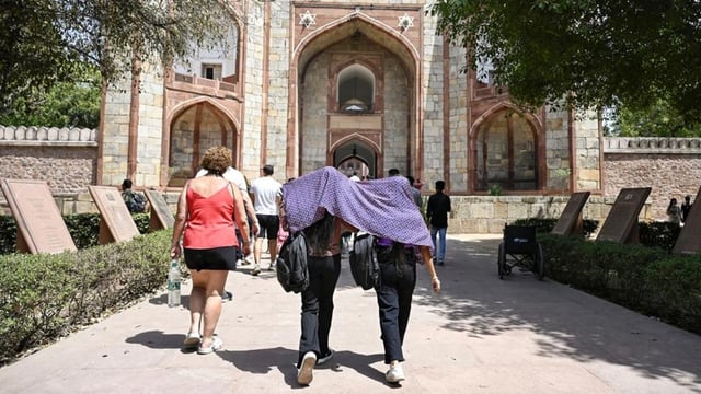 Girls drape a scarf as the sun casts its heat at Humayun's tomb in New Delhi last week.