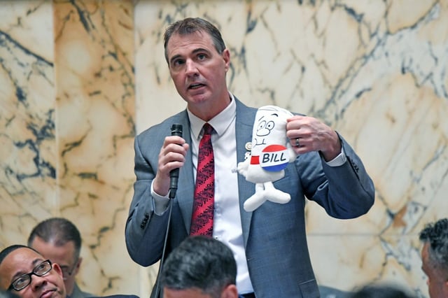 Del. Brian Chisholm, R-Anne Arundel County holds the bill from Schoolhouse Rock! during the last Saturday House session of the Maryland General Assembly before Sine Die at midnight on Monday. (Kim Hairston/Staff)