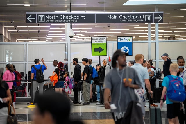Travelers stand in a long line for security screening at Hartsfield-Jackson Atlanta International Airport. Starting on May 7, travelers will be required to show REAL ID licenses, unless they have passports or other approved ID.